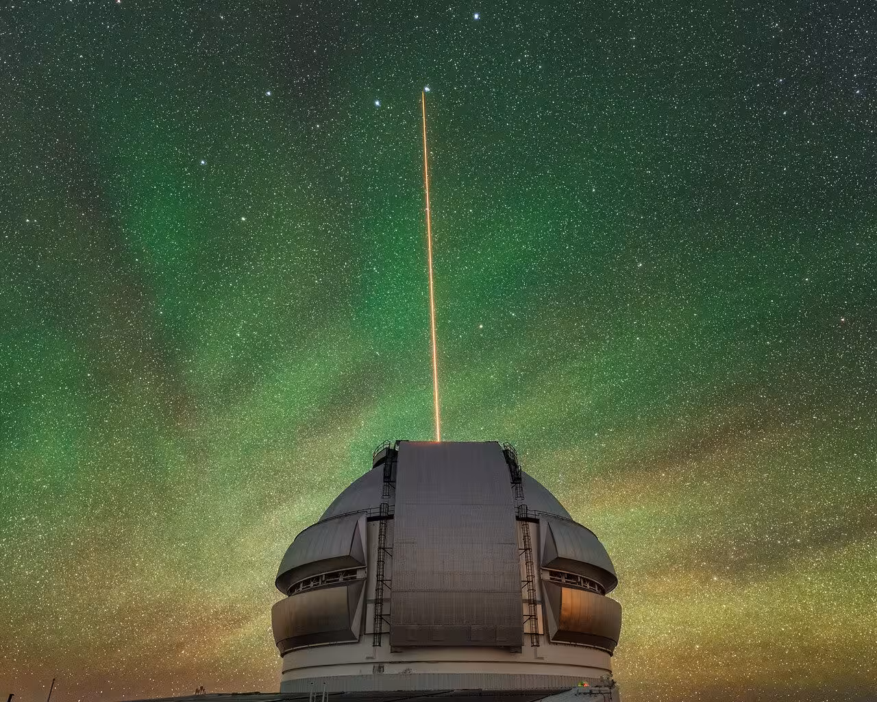 Gemini North’s laser shines through airglow. The Gemini North telescope’s laser guide star beams up into the atmosphere. 
