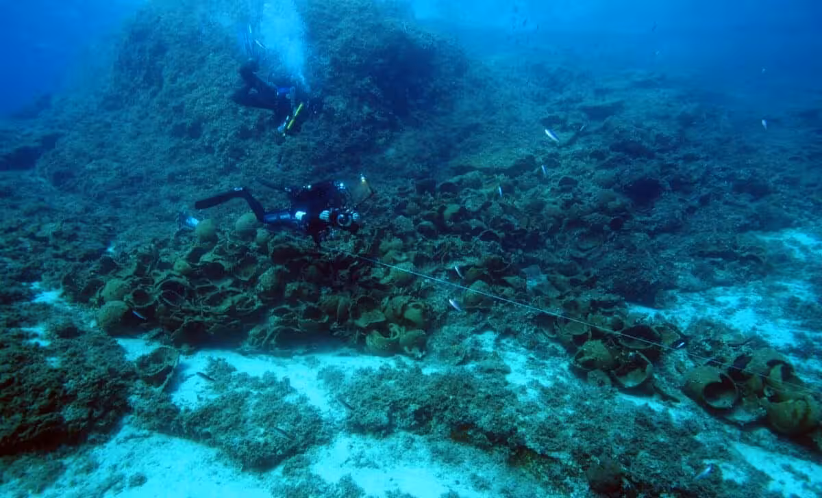 Amphorae Rest On The Seabed As Archaeologists Investigate Shipwrecks Off Fourni Island.