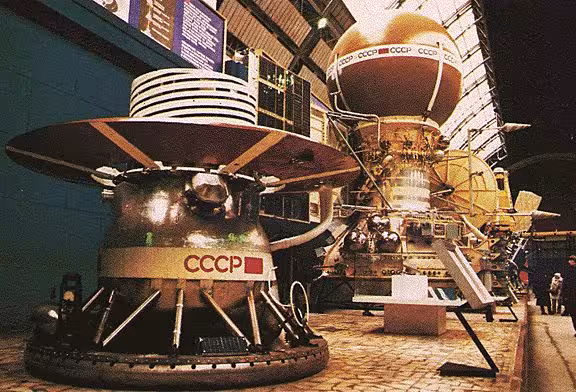 A mockup of the Venera 13 spacecraft is displayed at the Cosmos Pavilion of the Exhibition of the Achievements of the National Economy in Moscow, Russia. The lander module in the foreground would sit inside the brown sphere atop the Venera spacecraft (background).