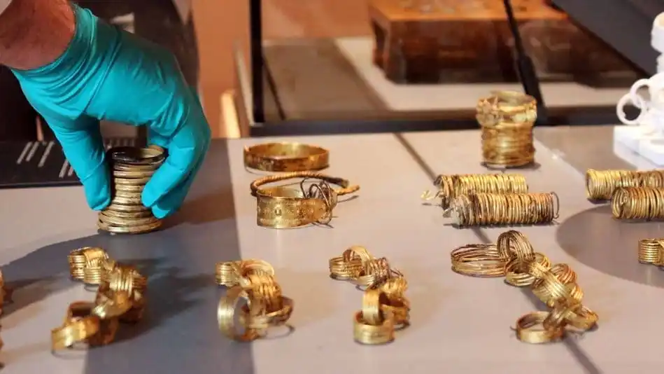 A Gloved Hand Handles Gold Artifacts From The Gessel Gold Hoard