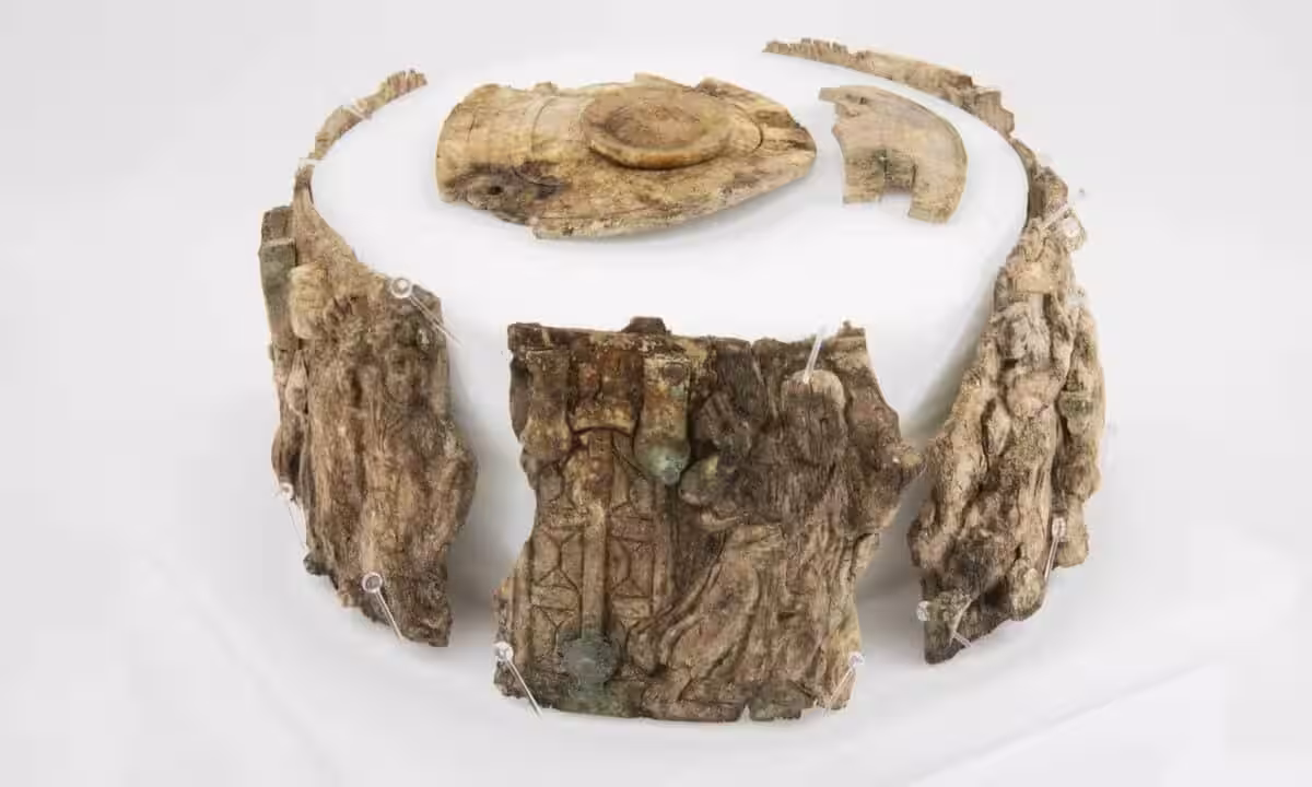 Ivory Fragments From The Ancient Pyx Displayed In A Circular Arrangement On A White Surface.