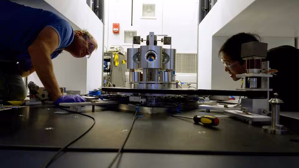Nist Scientists Stephan Schlamminger (left) And Vincent Lee Examine The Torsion Balance Used To Measure Big G.