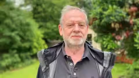 Tony McAleavy looks at the camera wearing black rain jacket
