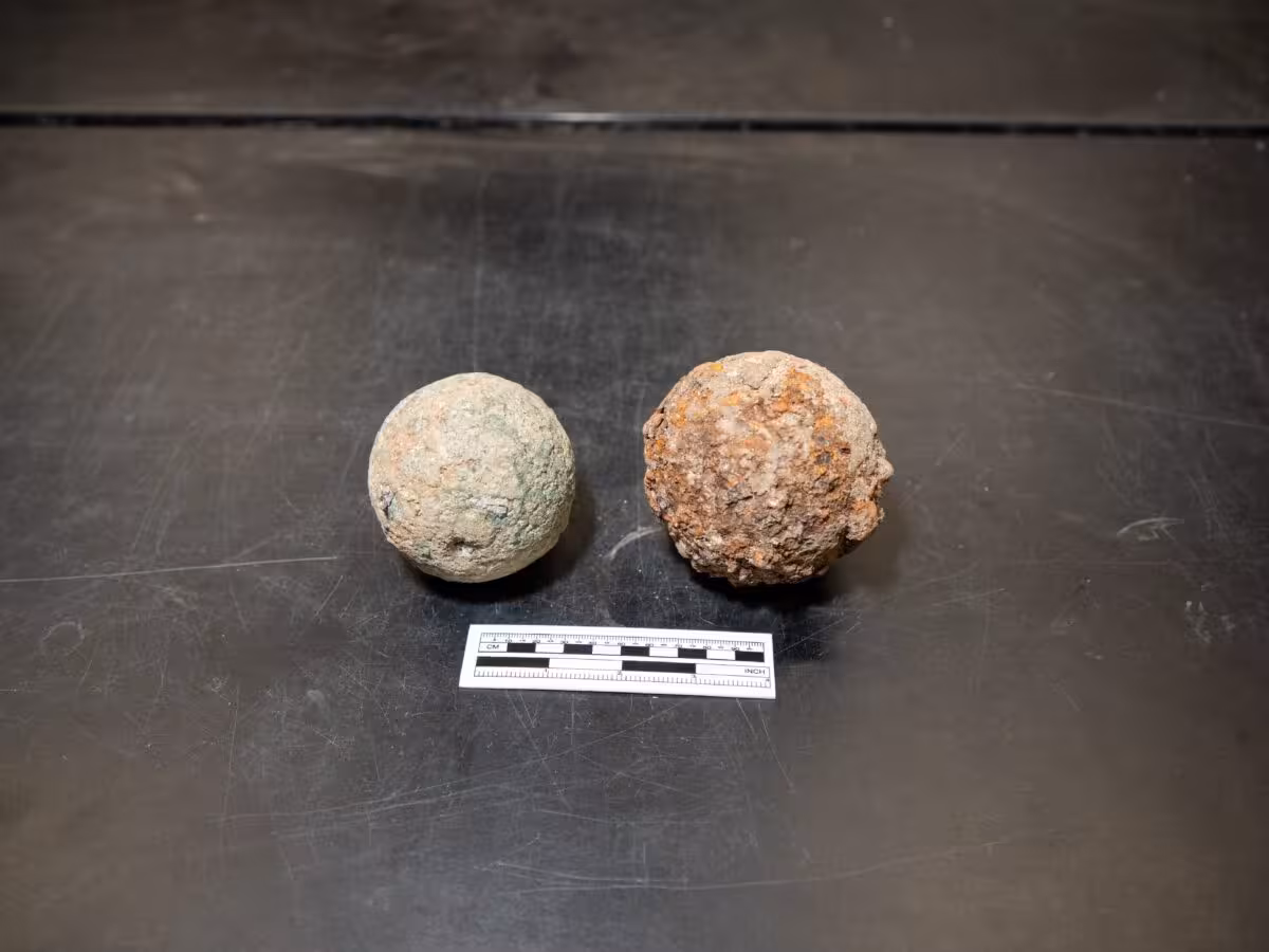 Two Cannonballs Discovered At The Alamo Are Shown Side By Side.