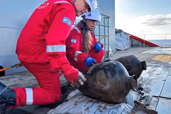 IAA archaeologist Jacob Sharvit, left, and Energean environmental lead Karnit Bahartan examine two Canaanite storage jars after their retrieval from the seafloor of the Mediterranean on May 30, 2024.