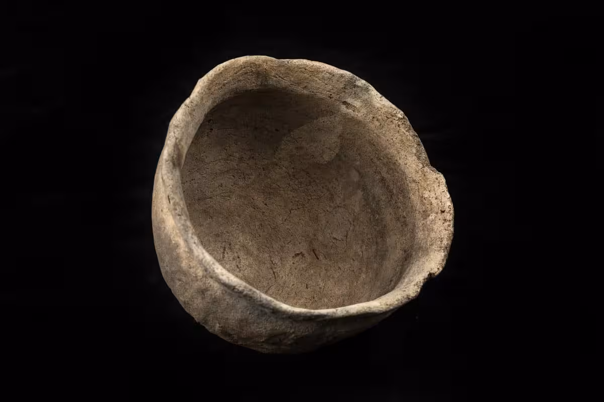 An Old Ceramic Vessel Photographed After Excavation, Highlighting Its Unusual Shape And Preserved Details.