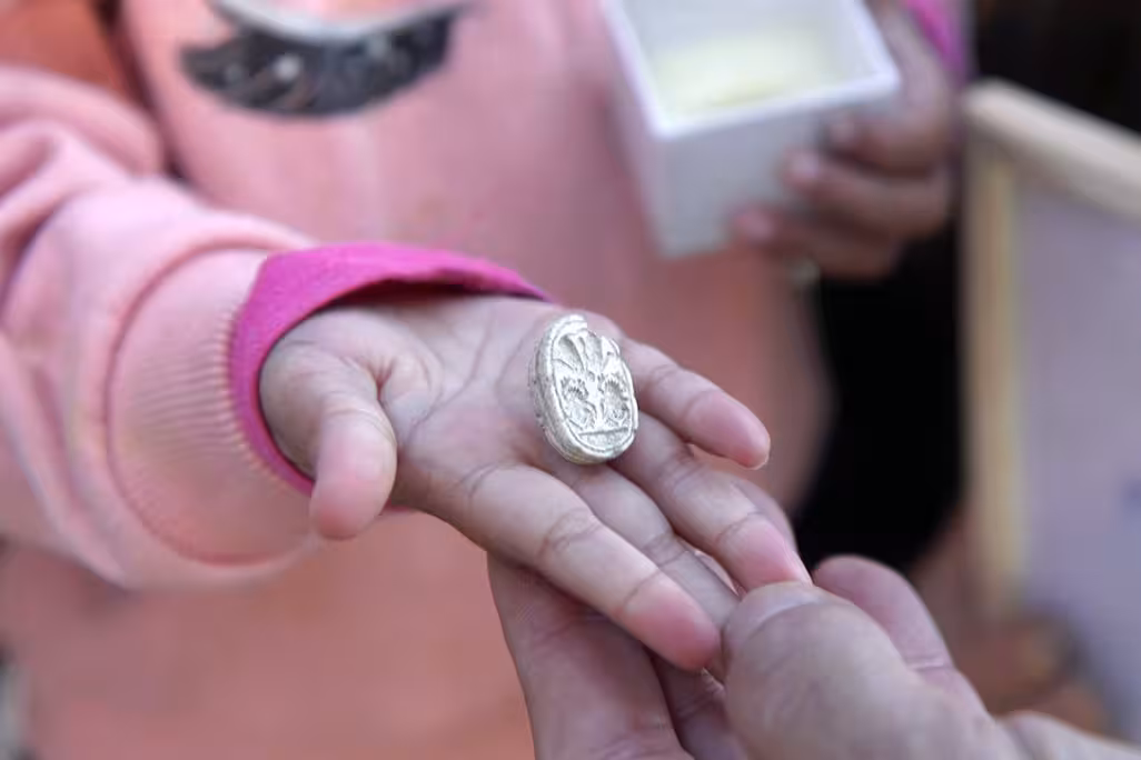 Little girl's hand holding a small decorative stone