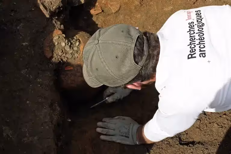 A Researcher Excavates One Of The 1,800 Year Old Roman Coin Hoards.
