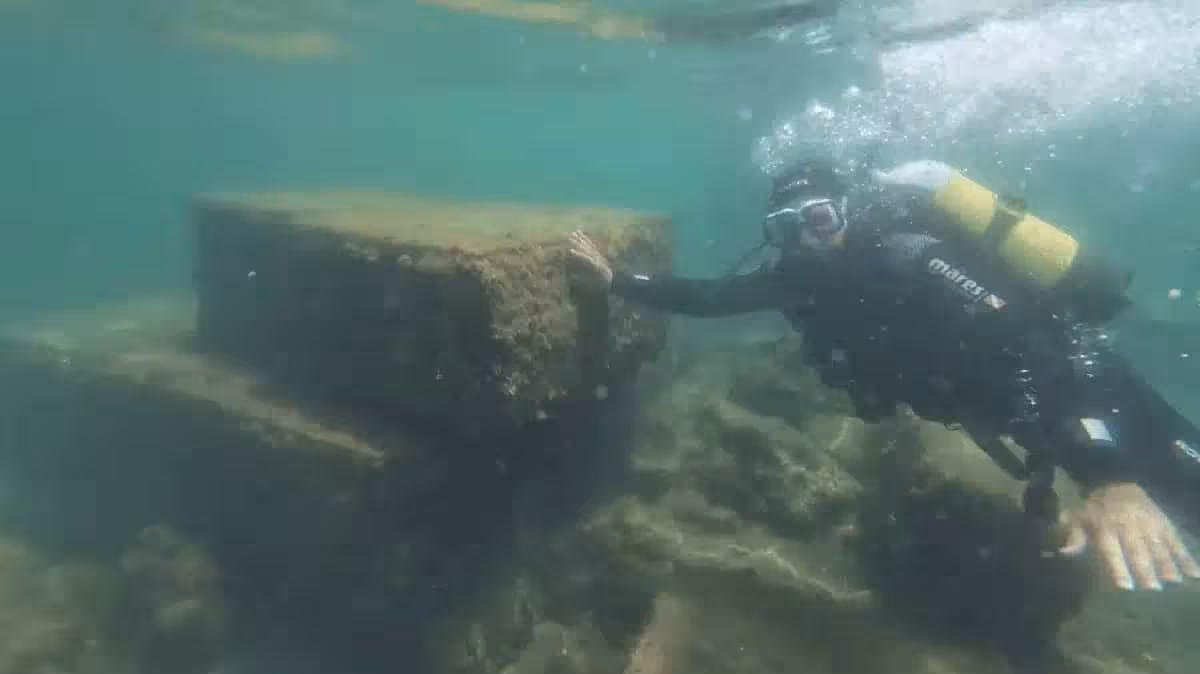 An Underwater Archaeologist Examines The Remains Of An Ancient Roman Structure Submerged Beneath The Bay Of Naples