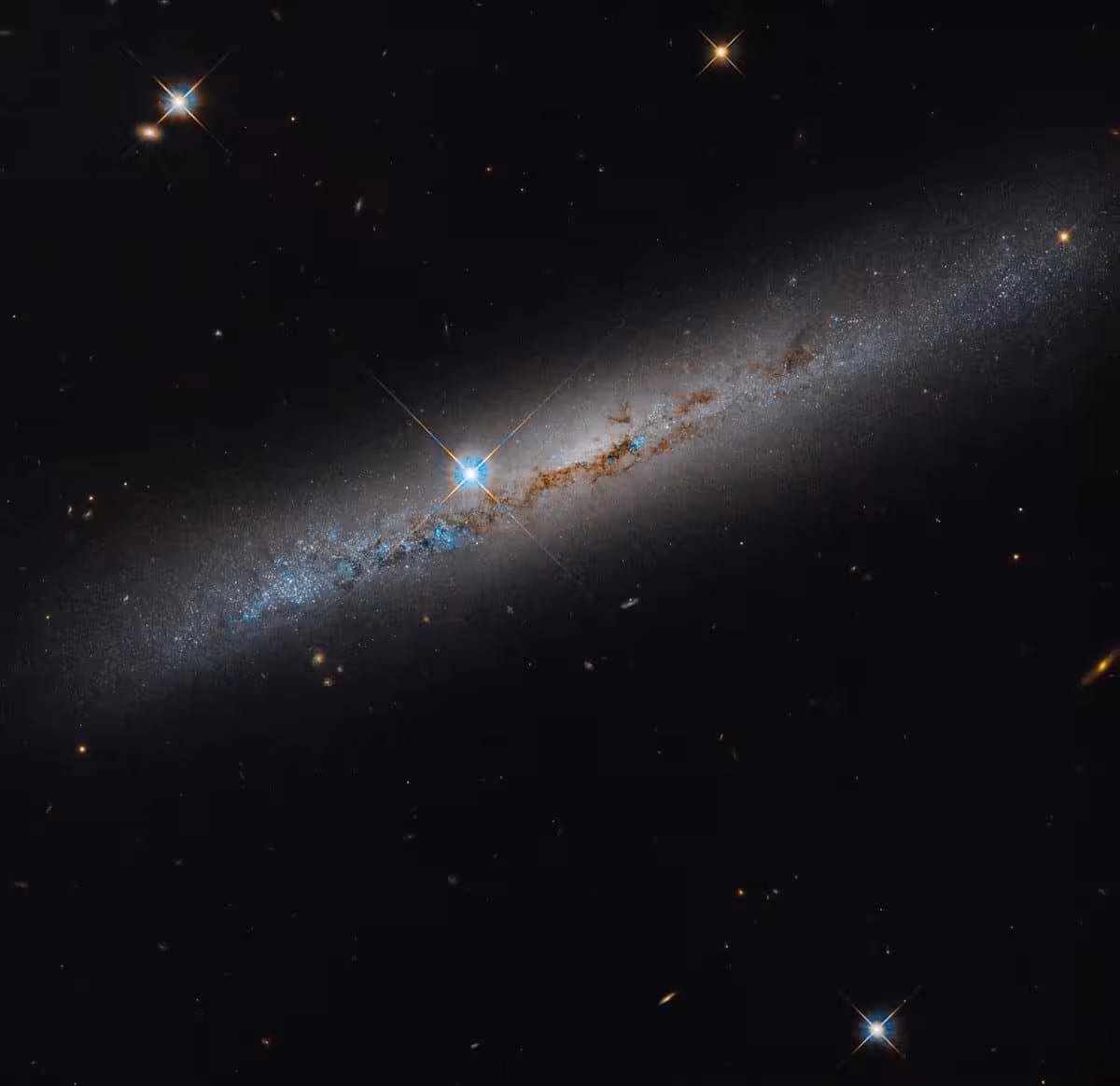 Hubble's View Of Ngc 1827 Reveals Rusty Brown Dust Lanes And Scattered Foreground Stars.