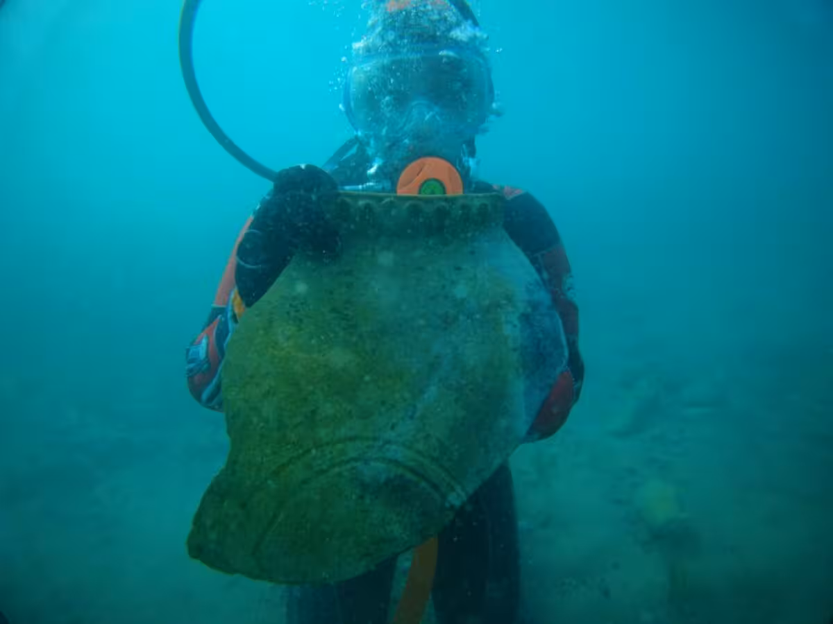 A Diver Recovers An Ancient Ceramic Jug From The Submerged Ruins Discovered Beneath Lake Issyk Kul.
