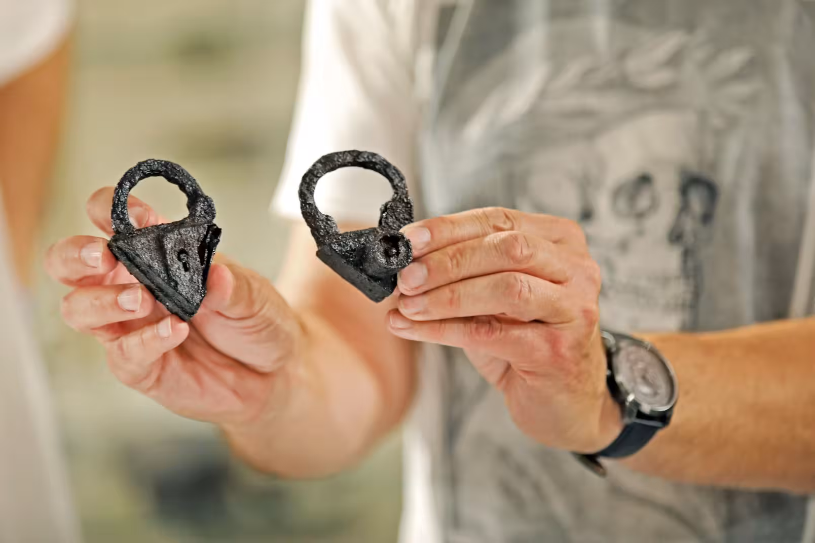 Man holding padlocks found in graves during archaeological work in Pień near Dabrowa Chelminska.