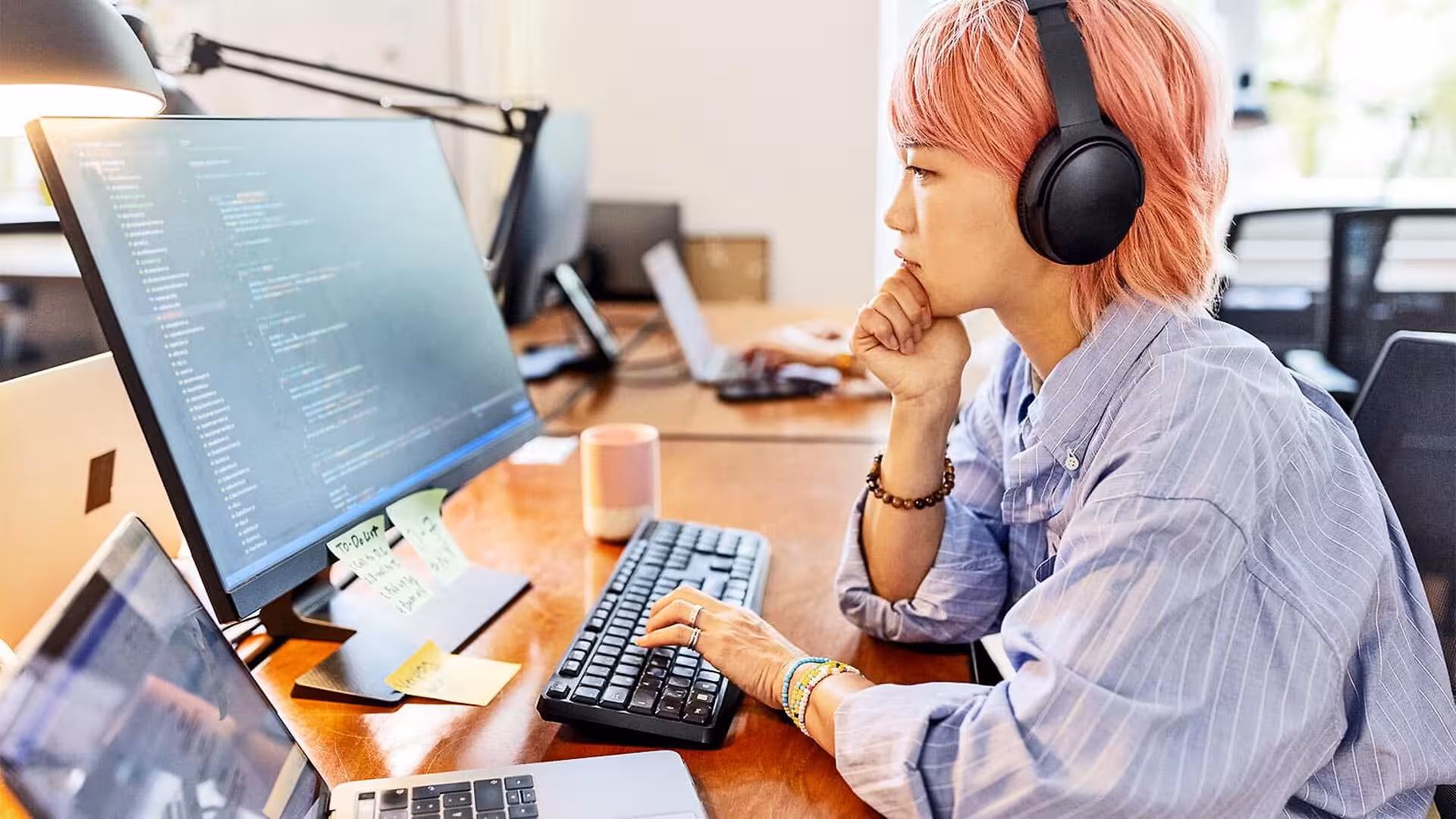 A woman works at a computer in an office.