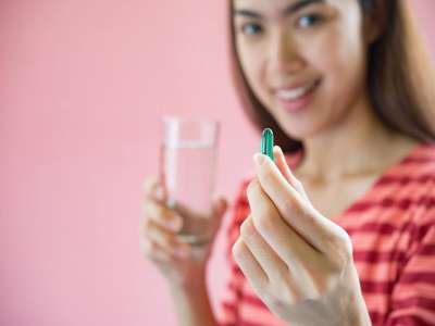 Young woman taking medicine pill after doctor order.