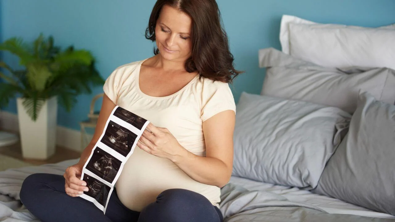 Pregnant woman browsing ultrasound image of her baby