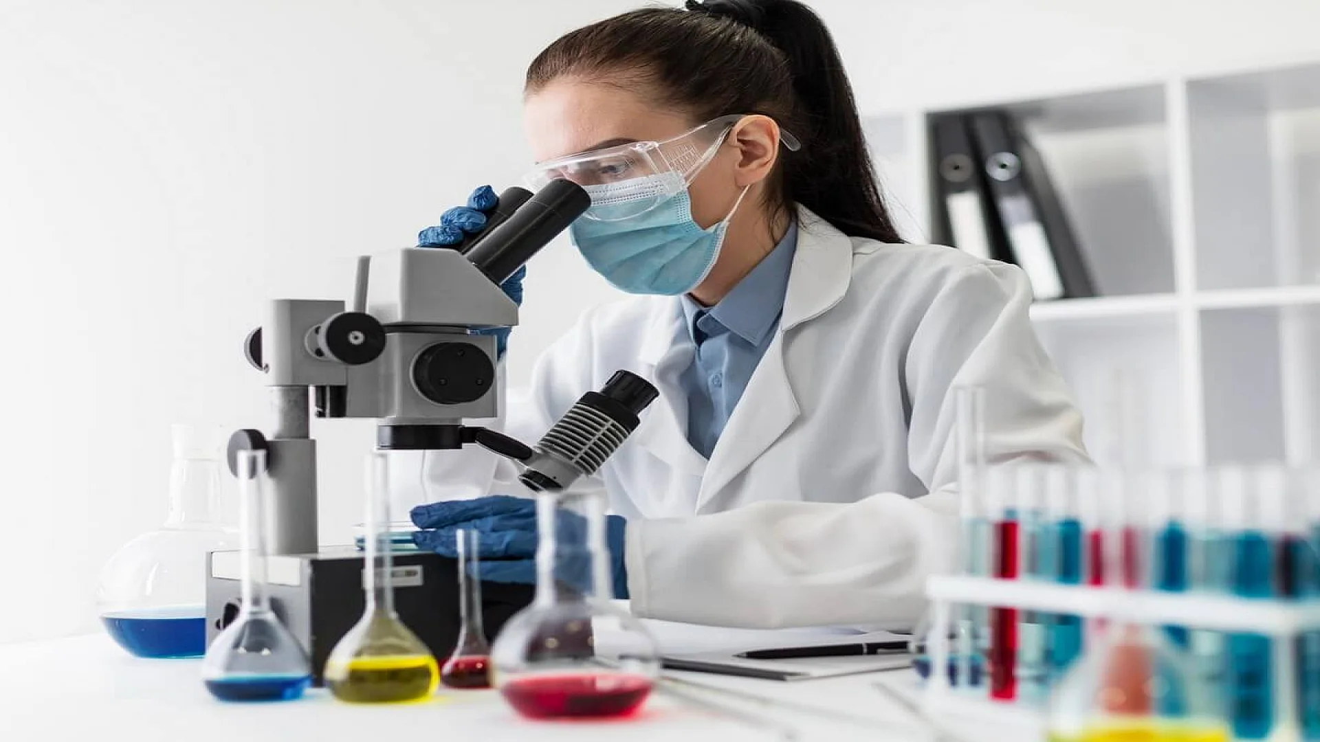 Free photo medium shot woman looking through microscope.