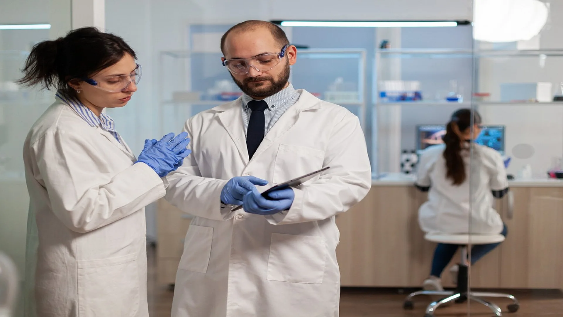 Chemist nurse explainig to doctor vaccine development in modern laboratory.