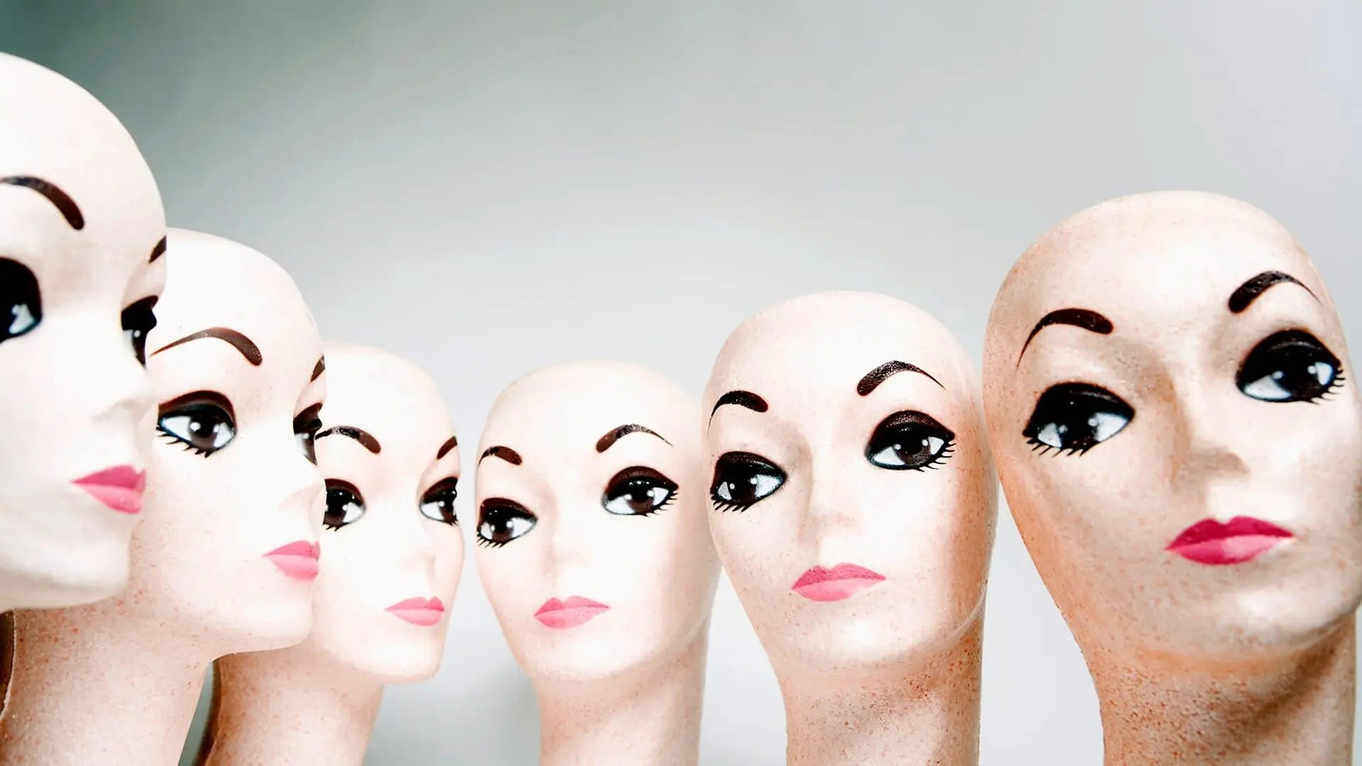 A row of identical mannequin heads.