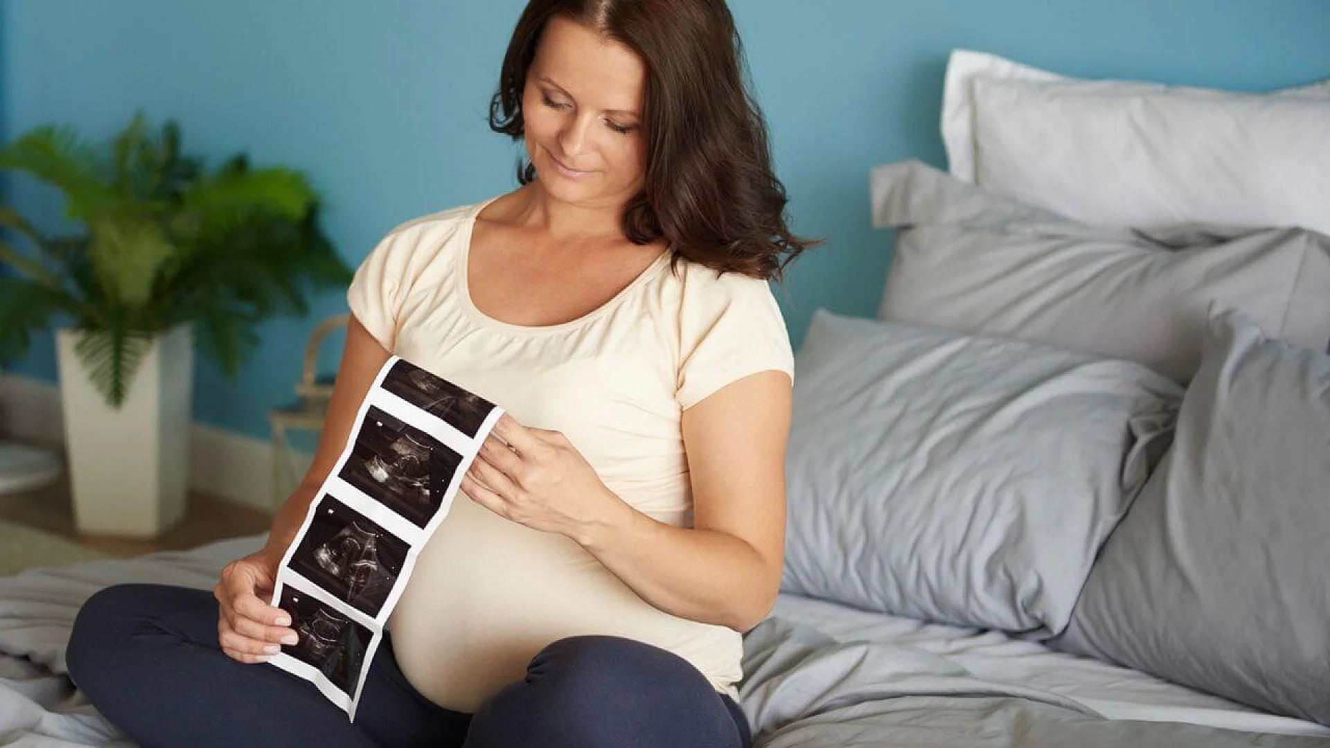 Pregnant woman browsing ultrasound image of her baby