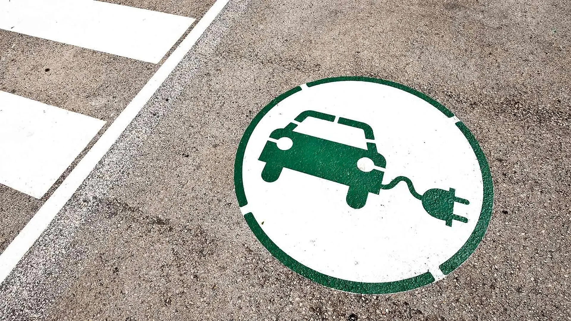 A painting in a parking spot shows a car charging its battery.
