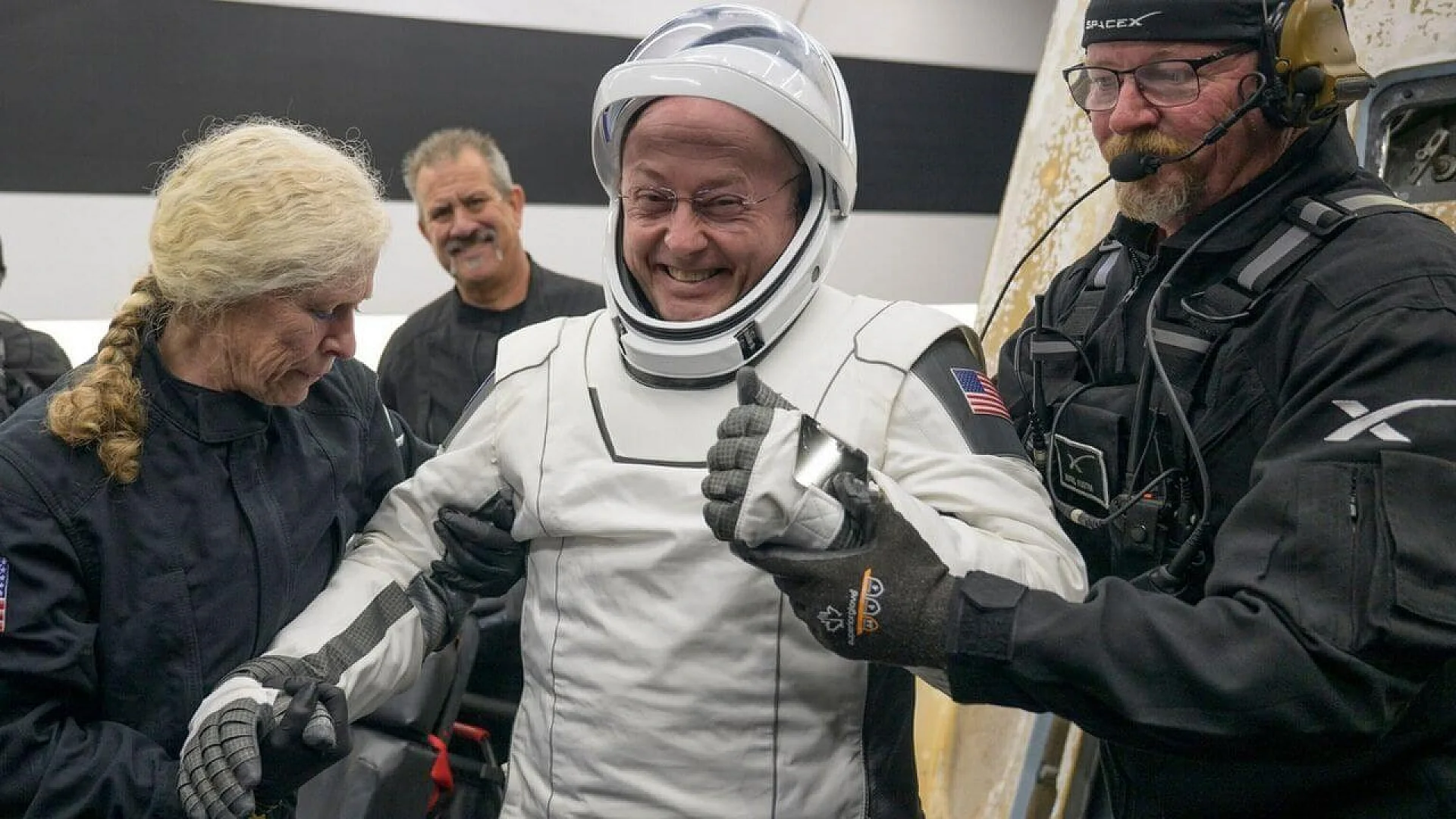 Assistants help NASA astronaut Mike Fincke exit the SpaceX Crew-11 capsule