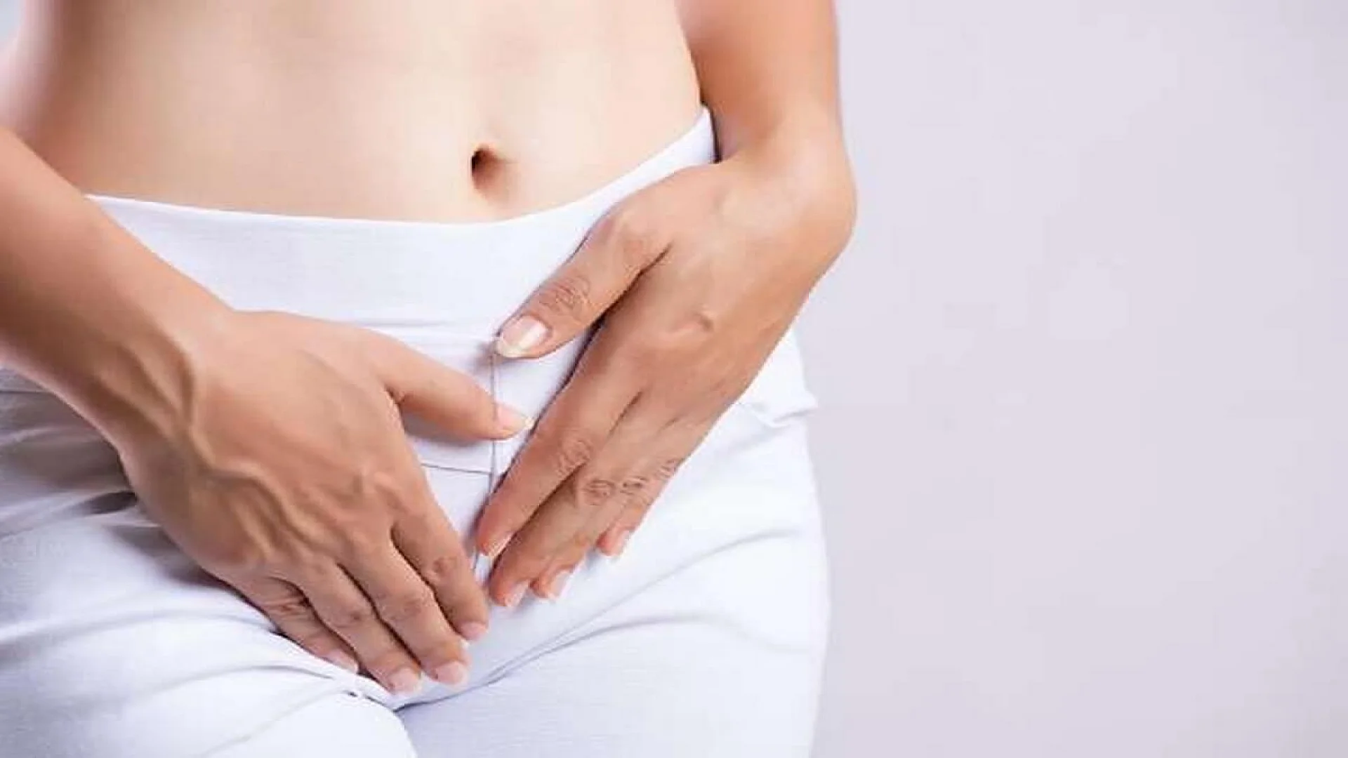 Young woman having painful stomachache with hands holding pressing her crotch lower abdomen. Medical or gynecological problems, healthcare concept.