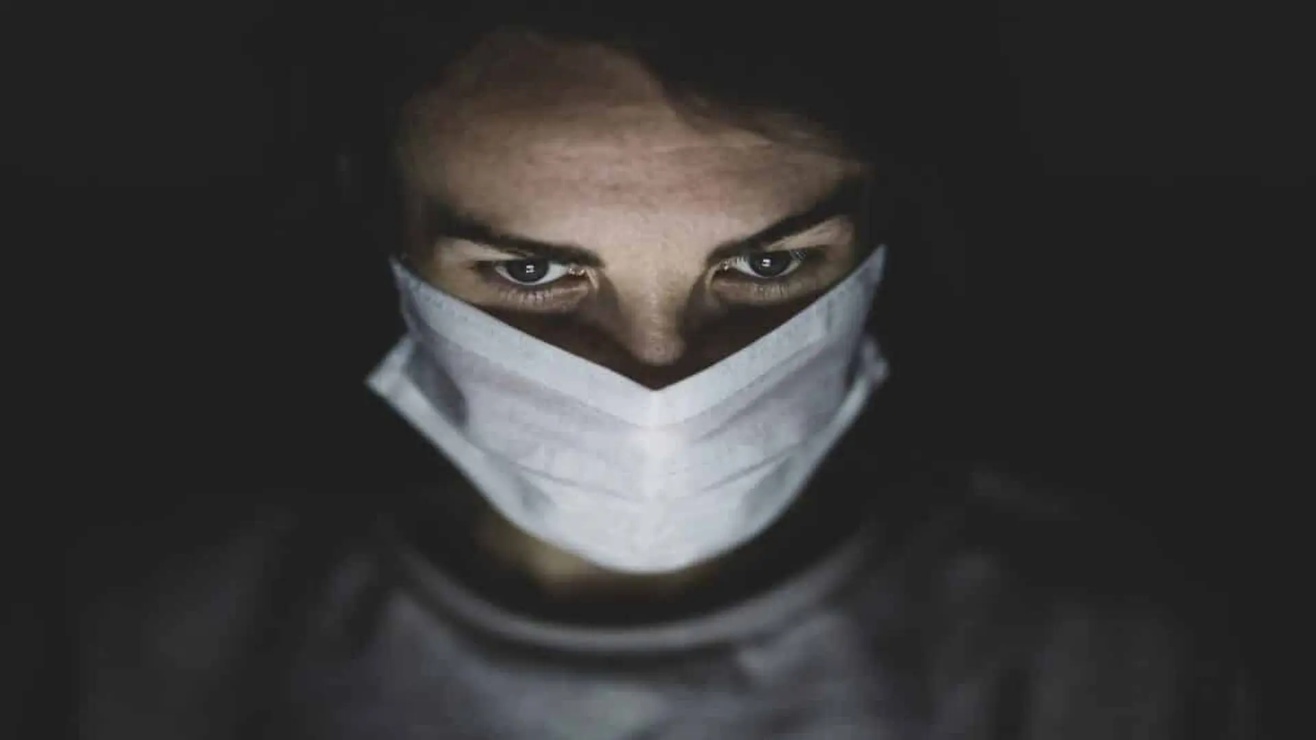 Man Wearing Face Mask In A Dark Room Scaled