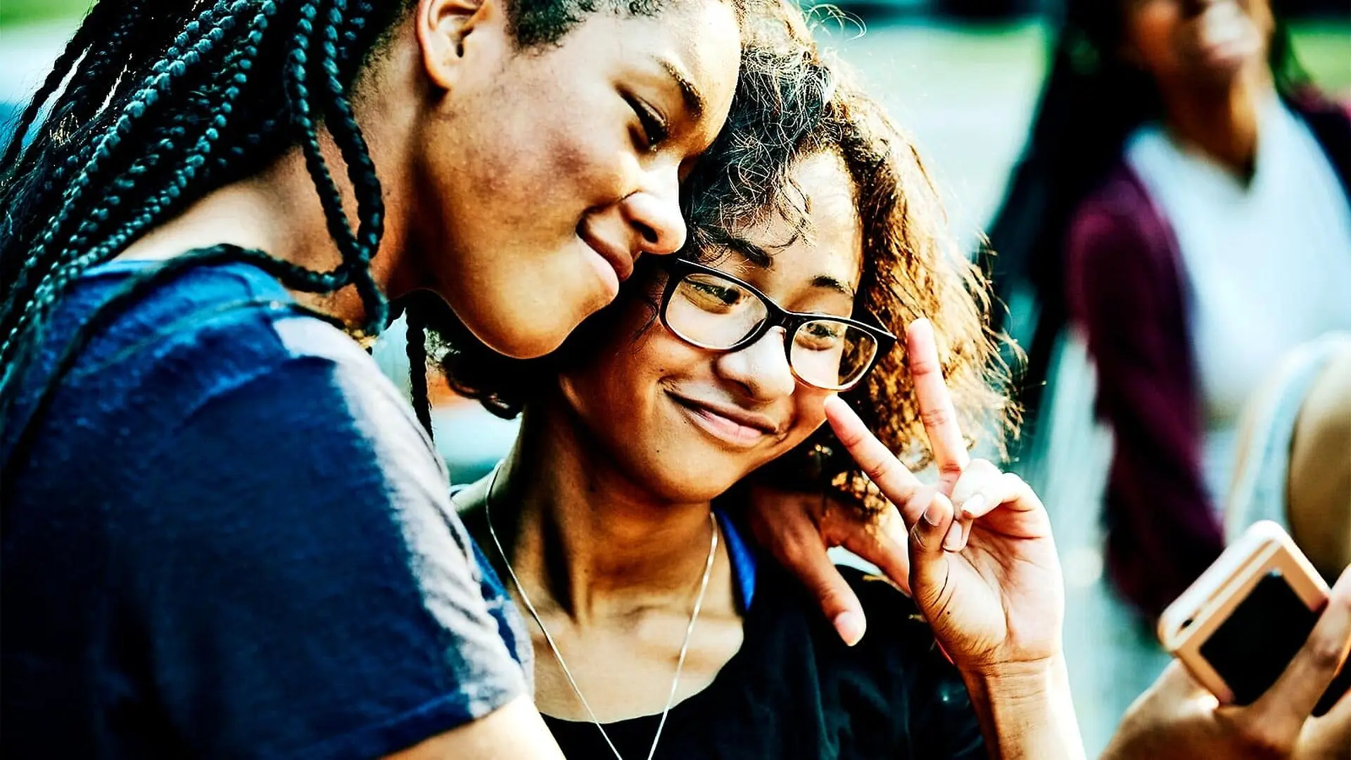 Two teen girls pose for a selfie while smiling.