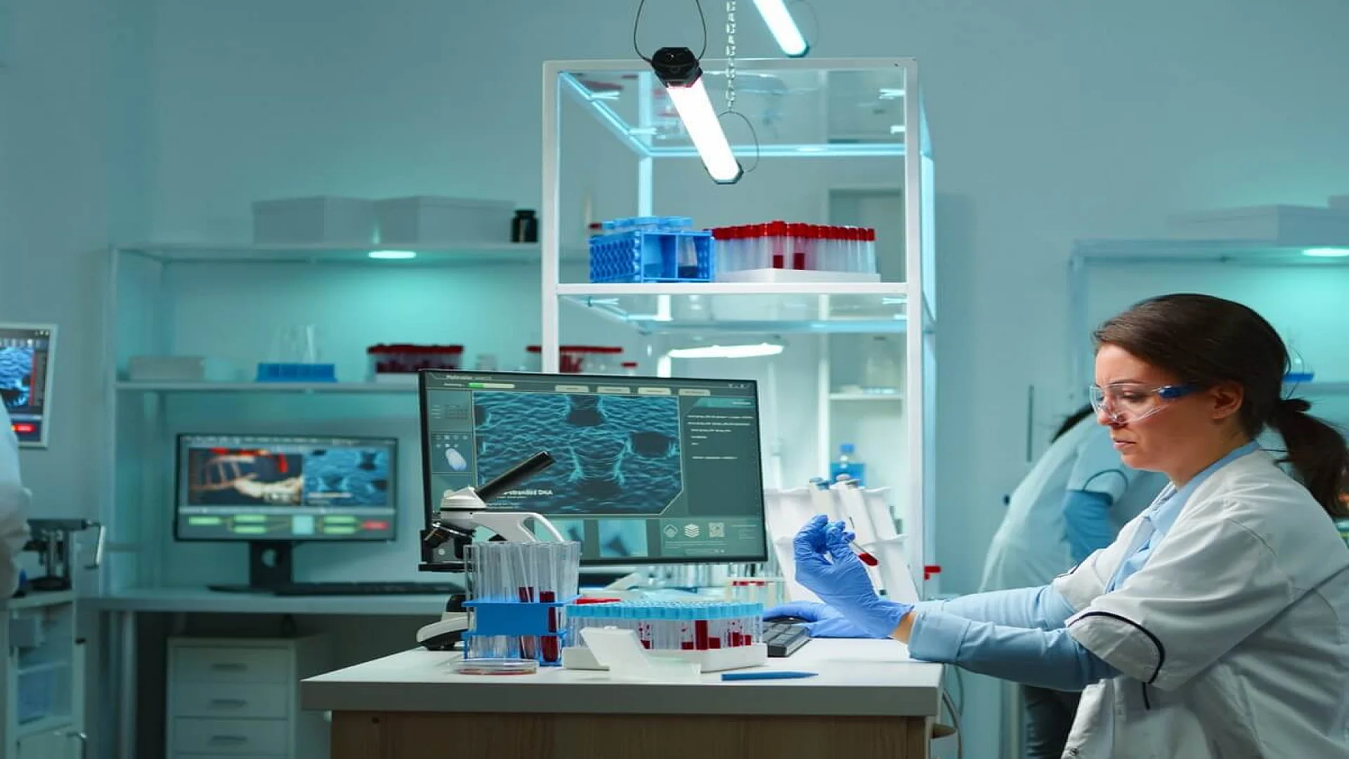 Medical lab worker analyzing blood serum conducting virus test in modern equipped lab late at night. team of specialists examining vaccine evolution using high tech for treatment against covid19.