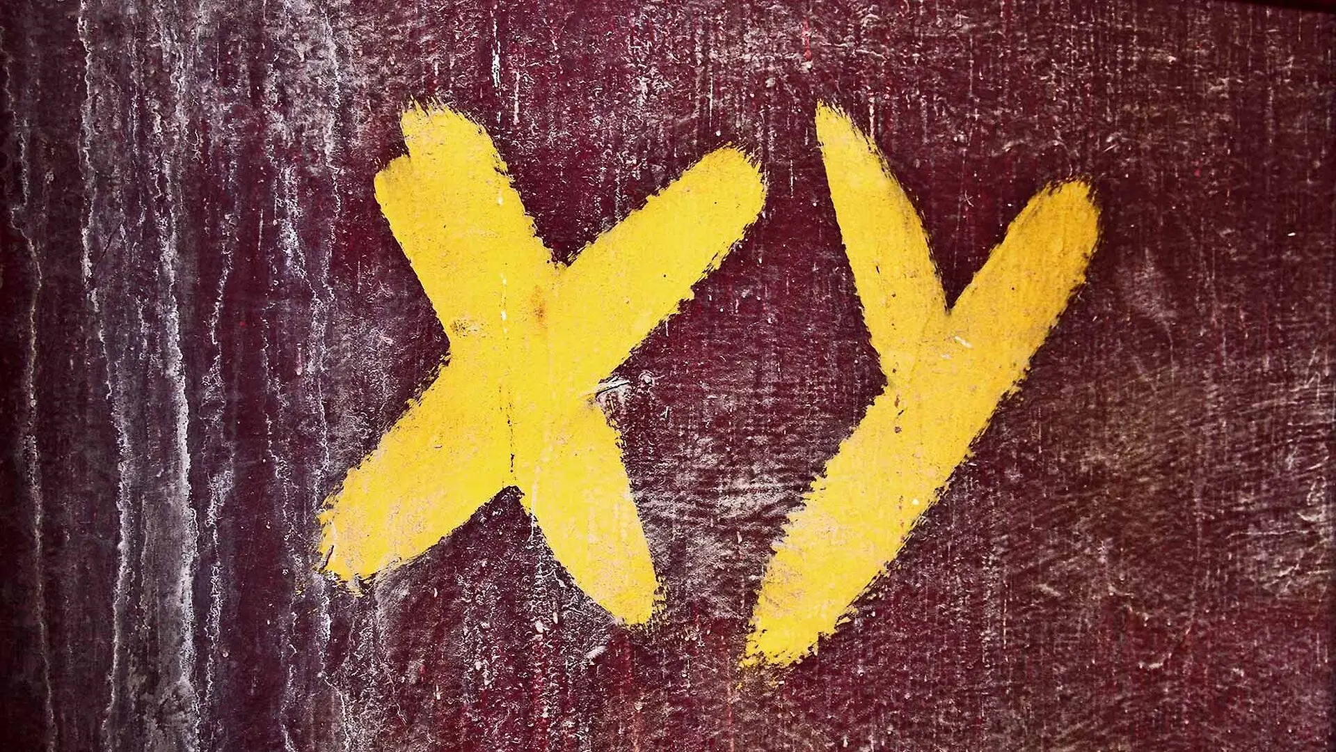 The letters X and Y painted on a wall in yellow.