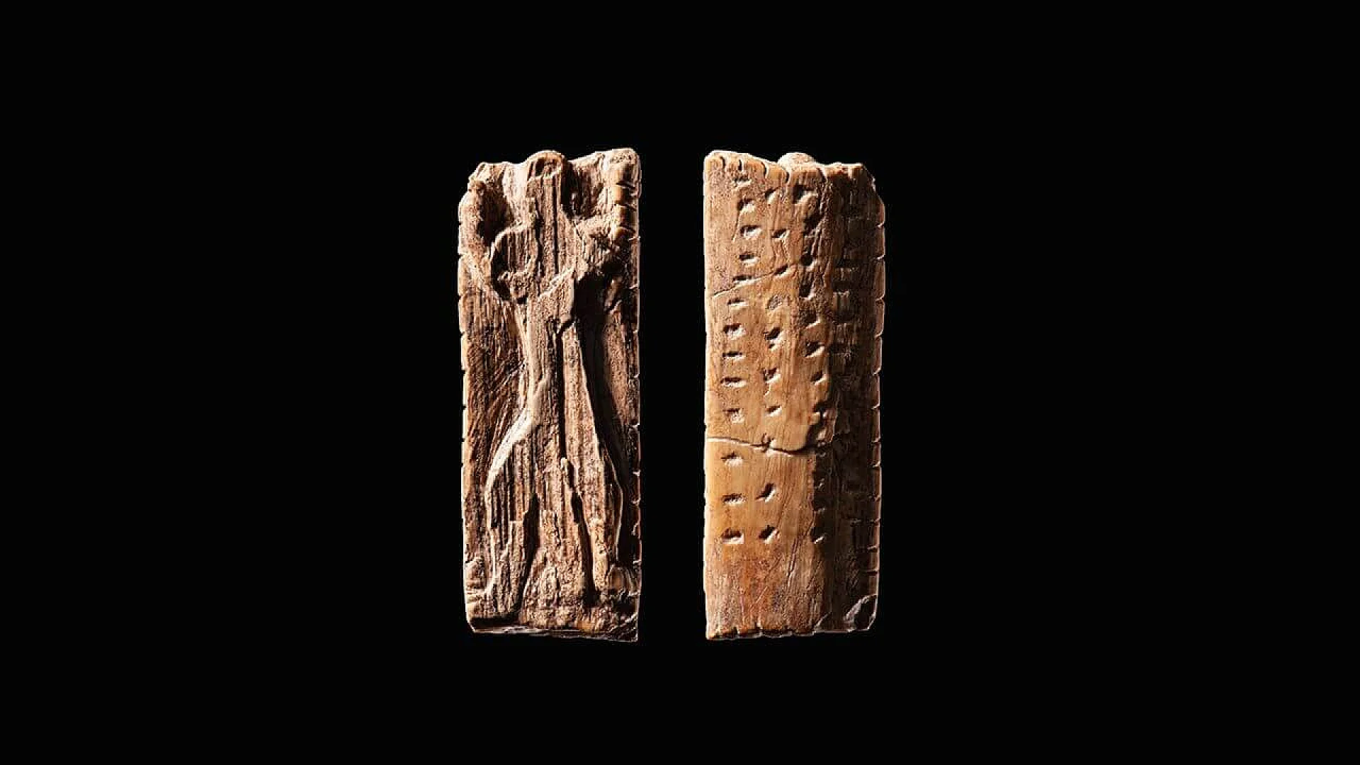 A 38,000-year-old ivory carving known as the Adorant figurine from Geißenklösterle Cave, featuring an anthropomorphic figure and deliberate rows of dots and notches that suggest an ancient information storage system.