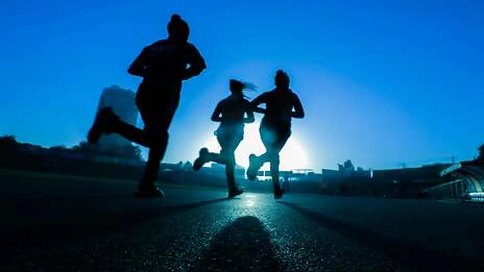 Three Runners Silhouetted Against The Sun