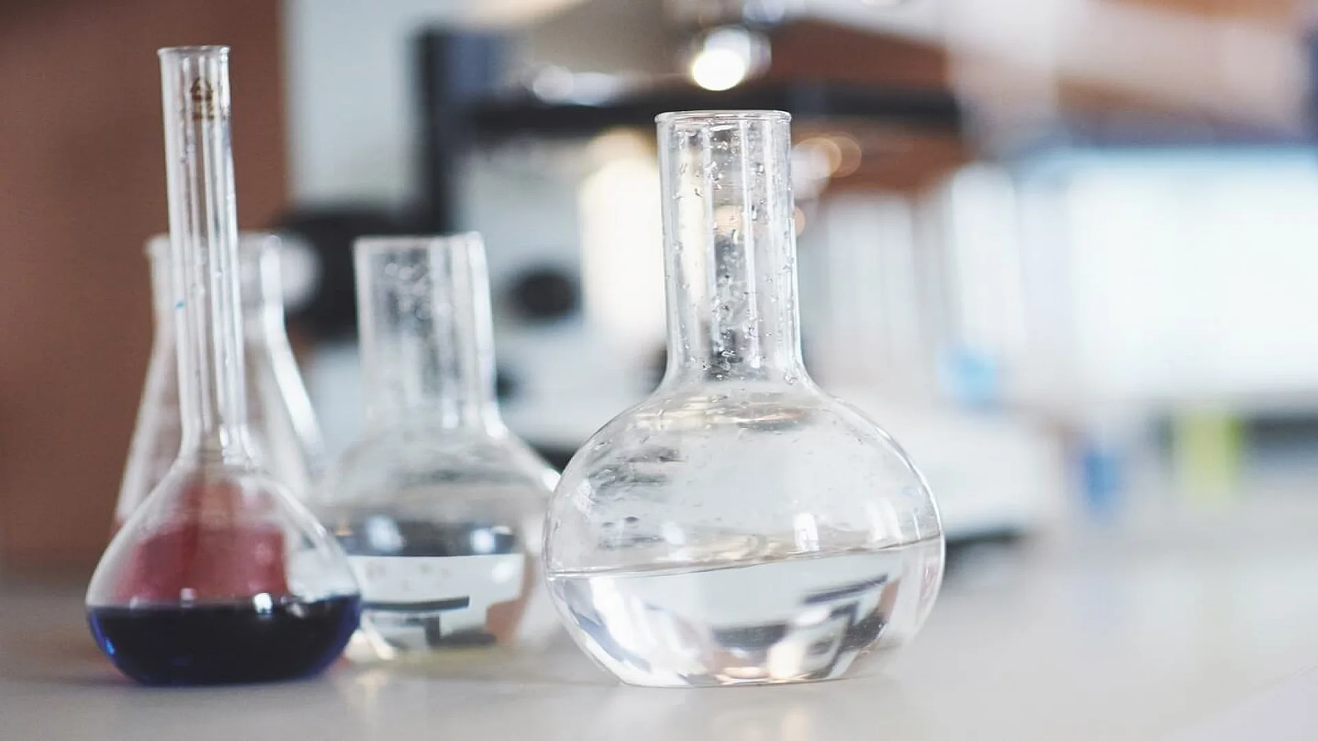 Free photo flask with blue purple pink liquid laboratory cork stand on the table in the test laboratory fluid testing.