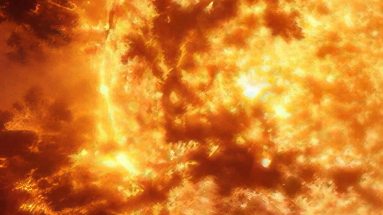 Diagram comparing a large, bright G-type star (like the Sun), a medium-sized, orange K-type star, and a small, red M-type star, illustrating that the K dwarf is the optimal stellar type for planetary stability and longevity.