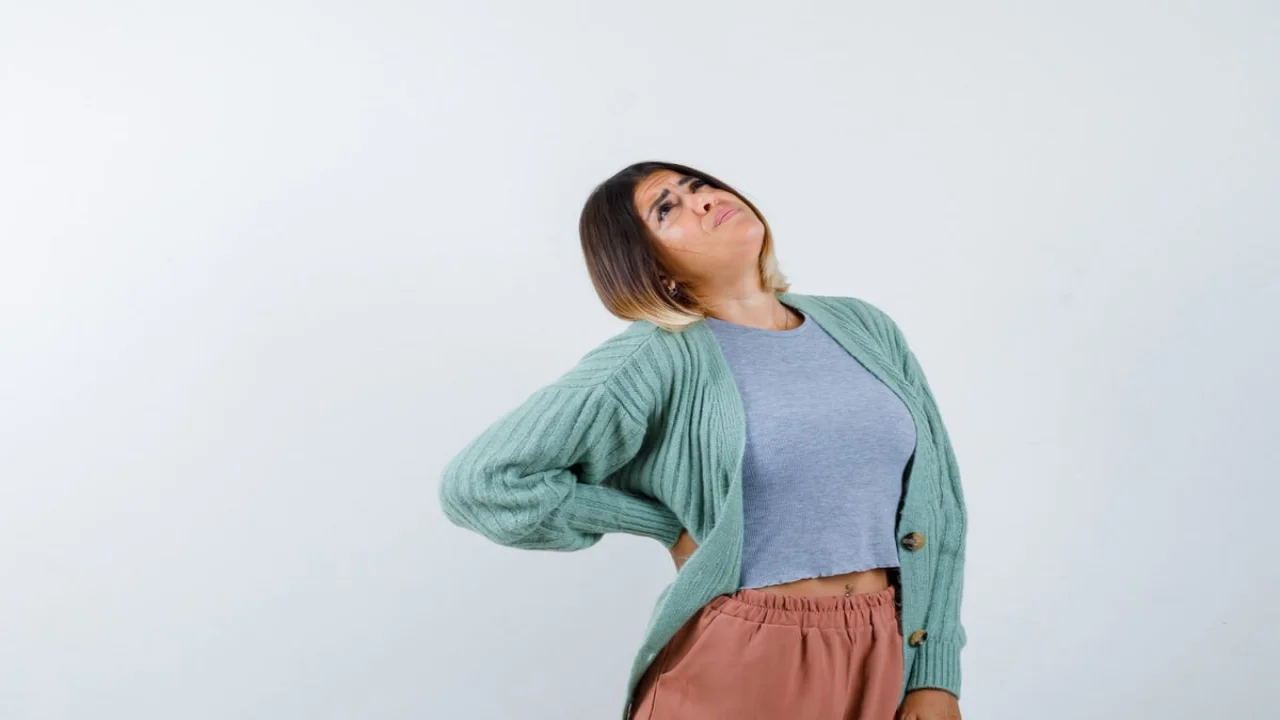 Woman in casual clothes holding hand on waist and looking hopeful , front view.