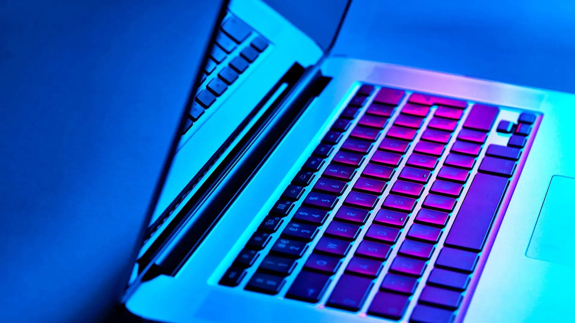 A laptop in blue and pink light.