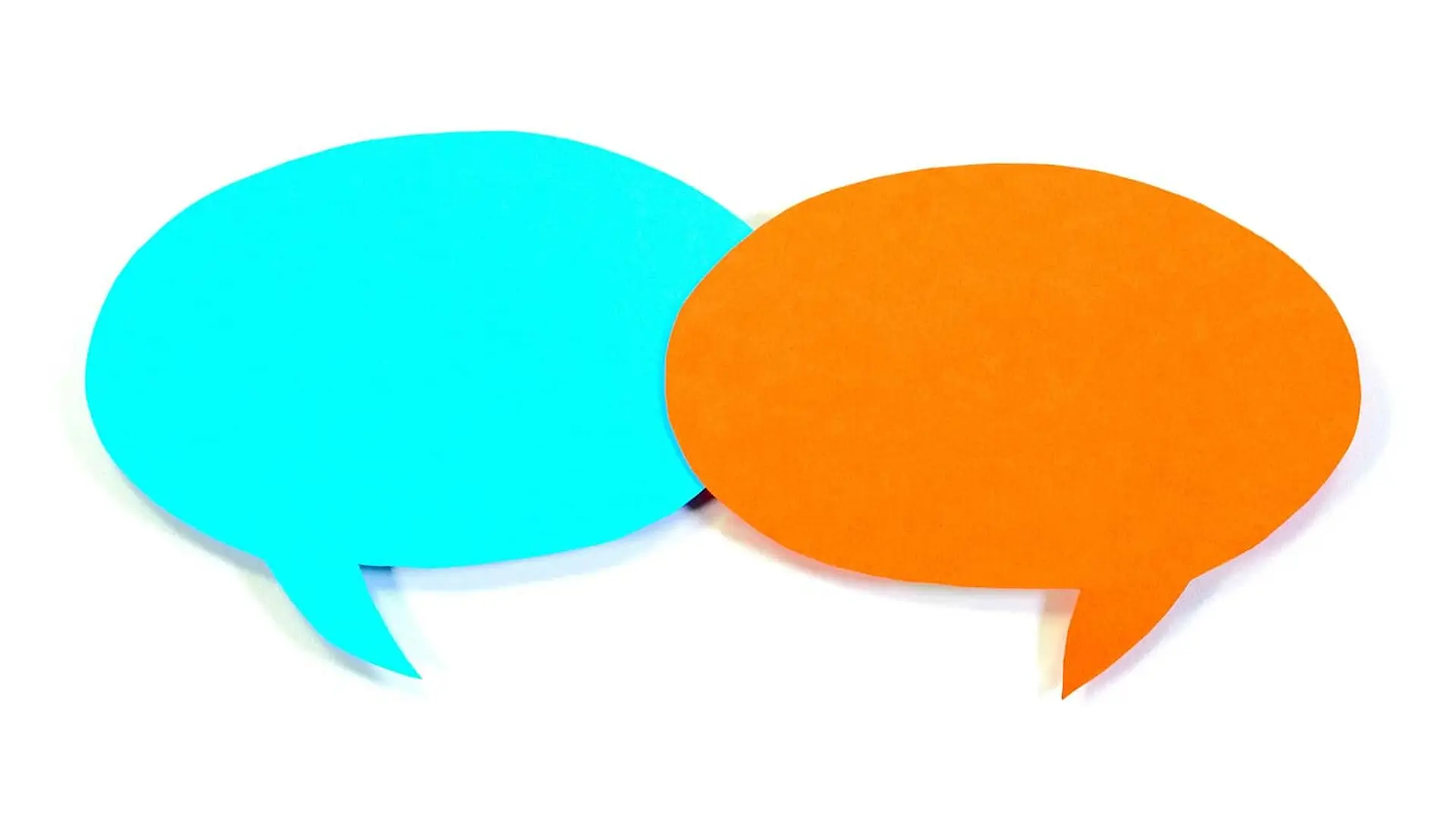 Two speech bubbles cut out of construction paper on a white background.