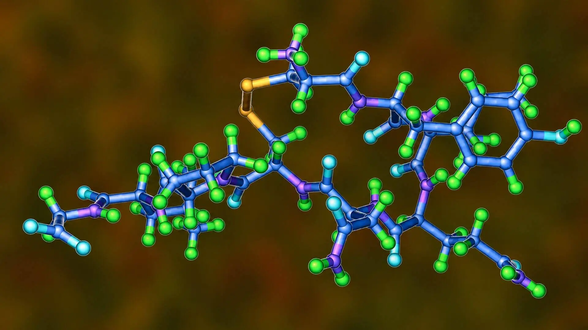 A three-dimensional ball-and-stick molecular model representing the GHK-Basic tripeptide, showing its connected amino acid chains with a distinct yellow disulfide bridge linking two segments against a blurred brown background.