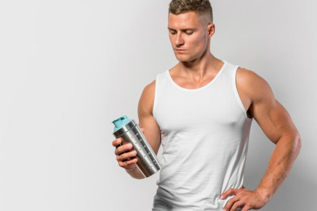 Front view of fit man with water bottle and copy space.