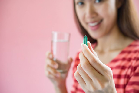 Young woman taking medicine pill after doctor order.