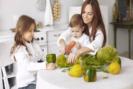 Free photo family preparing a salad in a kitchen.