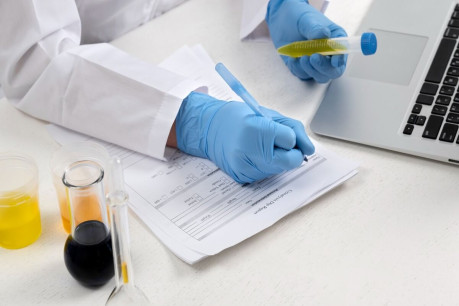 Lab doctor performing medical exam of urine.